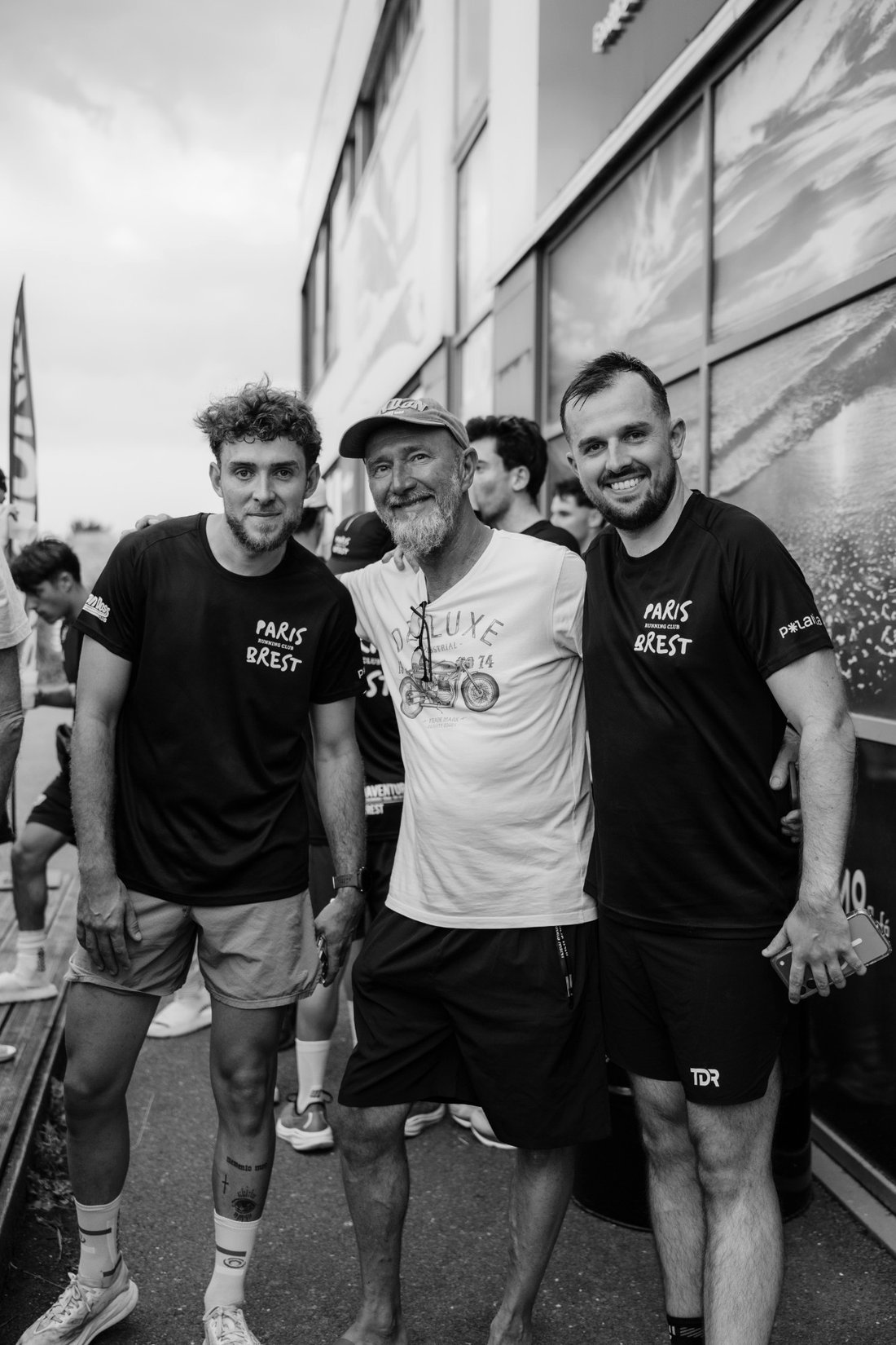 Trois participants posant ensemble, en t-shirt du Paris-Brest Running Club.